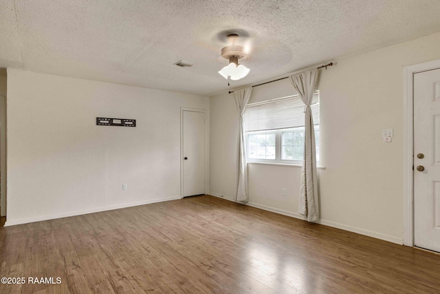 spare room featuring wood-type flooring and a textured ceiling