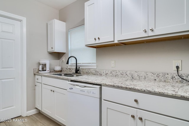 kitchen with white cabinetry, dishwasher, sink, and light stone counters