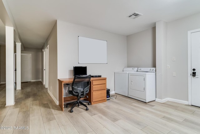 office area with light hardwood / wood-style flooring and washing machine and dryer