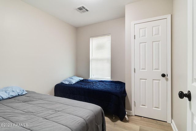 bedroom with multiple windows and light hardwood / wood-style floors