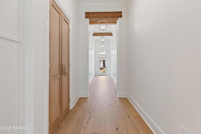 corridor with beam ceiling and light hardwood / wood-style flooring