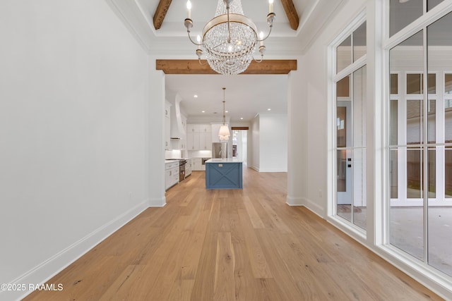 hallway with beam ceiling, ornamental molding, an inviting chandelier, and light hardwood / wood-style floors