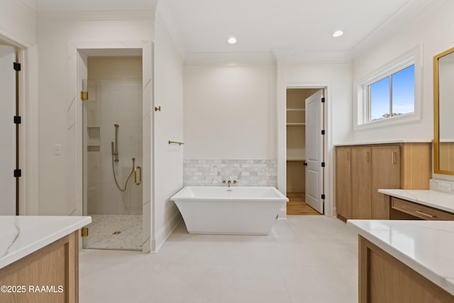 bathroom featuring ornamental molding, vanity, and shower with separate bathtub