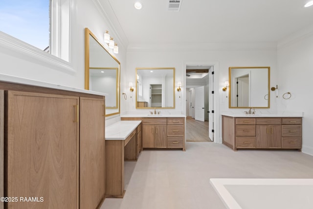 bathroom featuring crown molding and vanity