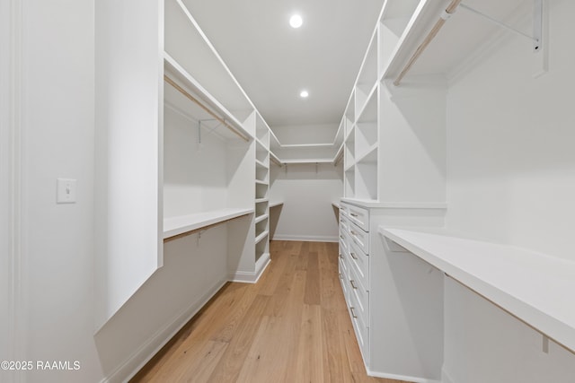 walk in closet with light hardwood / wood-style flooring