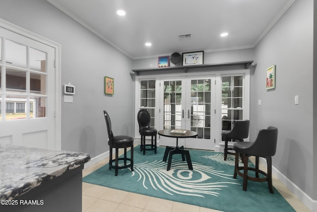 sitting room with light tile patterned floors, ornamental molding, and french doors