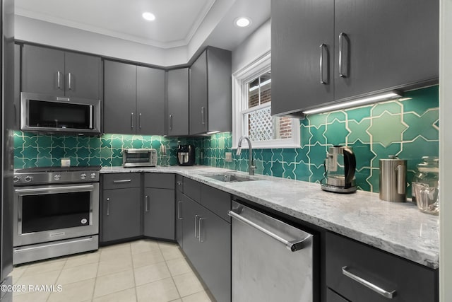 kitchen featuring tasteful backsplash, sink, light tile patterned floors, and appliances with stainless steel finishes