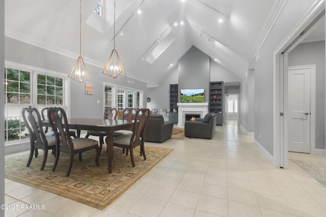 tiled dining area with crown molding, a skylight, and high vaulted ceiling