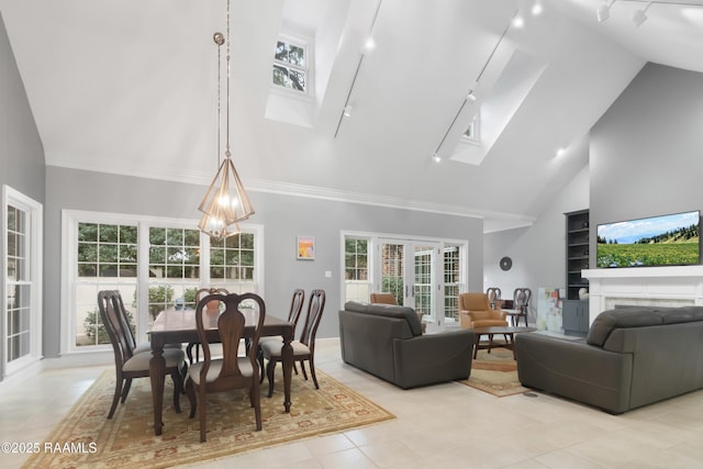 dining space with a healthy amount of sunlight, a chandelier, high vaulted ceiling, and a skylight