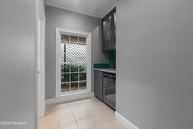 kitchen featuring tasteful backsplash, ornamental molding, black dishwasher, and light tile patterned floors