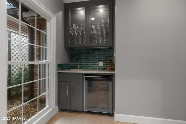 bar with wine cooler, a wealth of natural light, light tile patterned floors, and backsplash