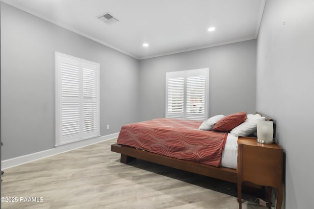 bedroom featuring ornamental molding and light hardwood / wood-style floors