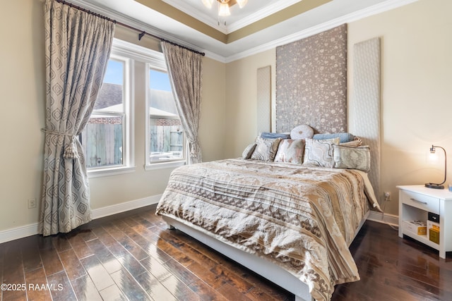 bedroom featuring multiple windows, ornamental molding, dark wood-type flooring, and a tray ceiling