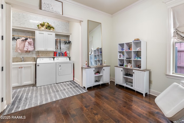 laundry room with sink, dark wood-type flooring, cabinets, ornamental molding, and washing machine and clothes dryer