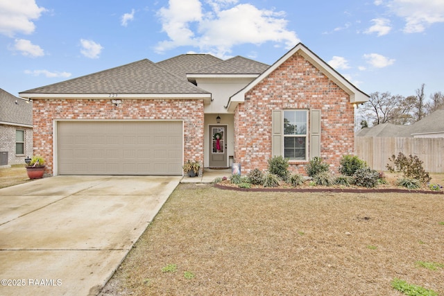 view of front property featuring a garage, central AC unit, and a front lawn