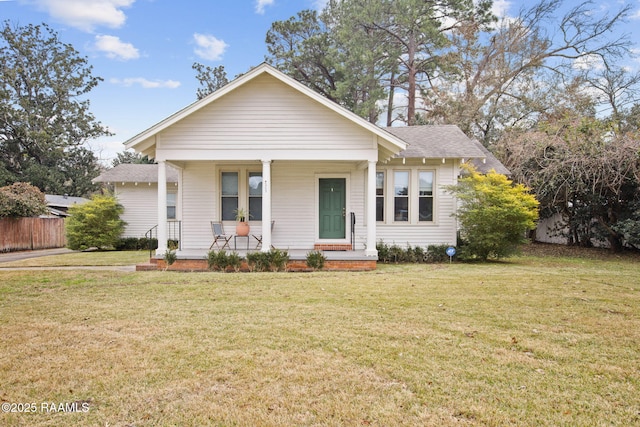 bungalow featuring covered porch and a front lawn