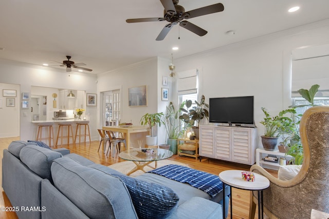 living room with ornamental molding, hardwood / wood-style floors, and ceiling fan