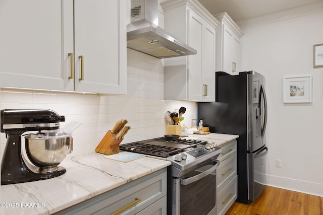 kitchen with range hood, white cabinetry, crown molding, light stone counters, and gas range