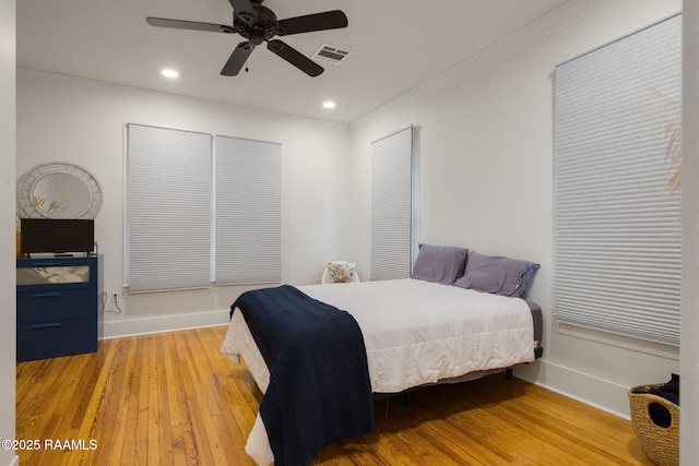 bedroom with ceiling fan, ornamental molding, and light wood-type flooring