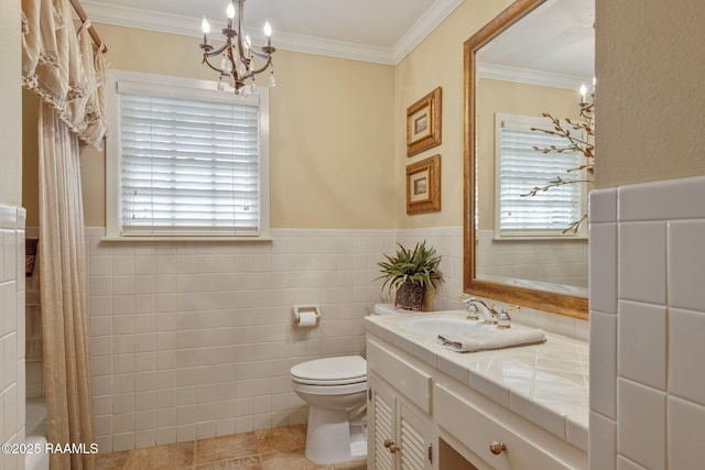 bathroom with ornamental molding, plenty of natural light, tile walls, and vanity