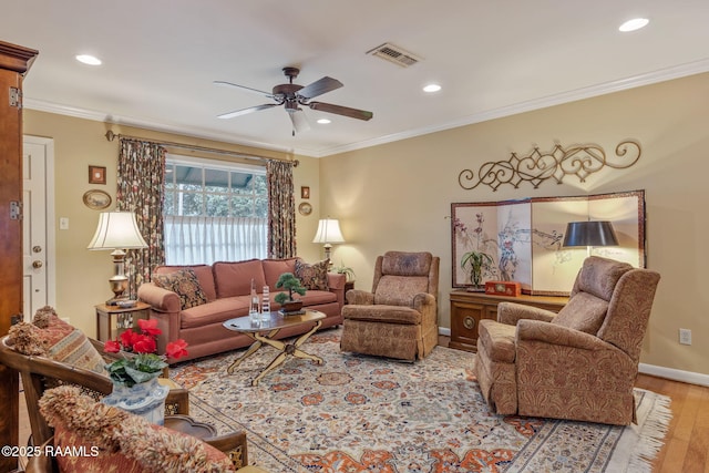 living room featuring ornamental molding, ceiling fan, and light hardwood / wood-style floors