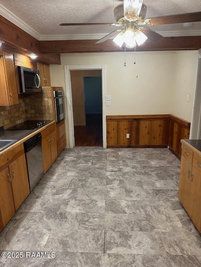 kitchen with appliances with stainless steel finishes, ornamental molding, a textured ceiling, decorative backsplash, and wood walls