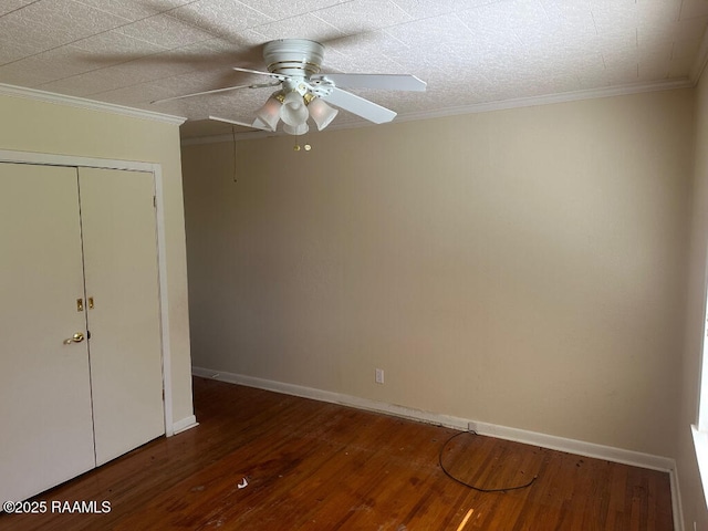 unfurnished bedroom with dark wood-type flooring, ceiling fan, ornamental molding, and a closet