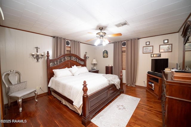 bedroom with dark wood-type flooring, ornamental molding, and ceiling fan