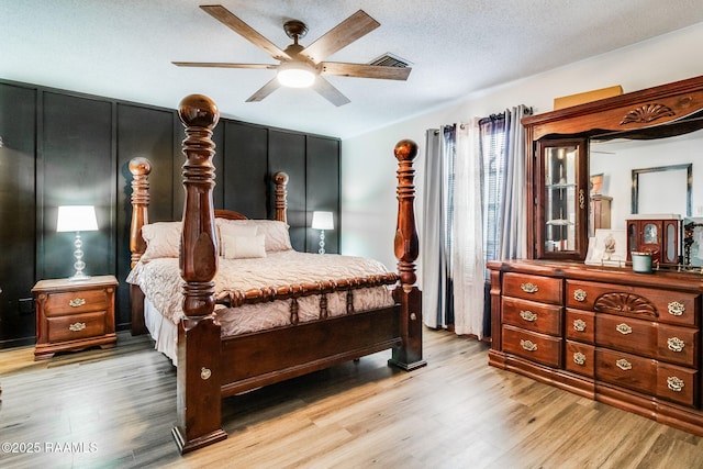 bedroom featuring ceiling fan, a textured ceiling, and light wood-type flooring