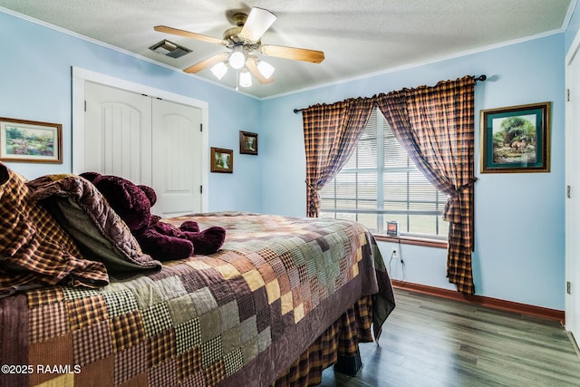 bedroom featuring crown molding, a closet, a textured ceiling, and hardwood / wood-style flooring