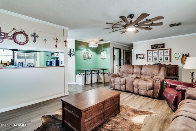 living room with ornamental molding, wood-type flooring, and a textured ceiling