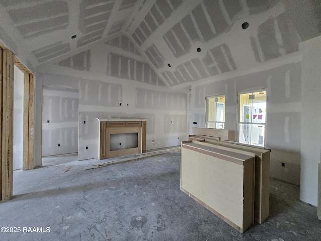 unfurnished living room with high vaulted ceiling