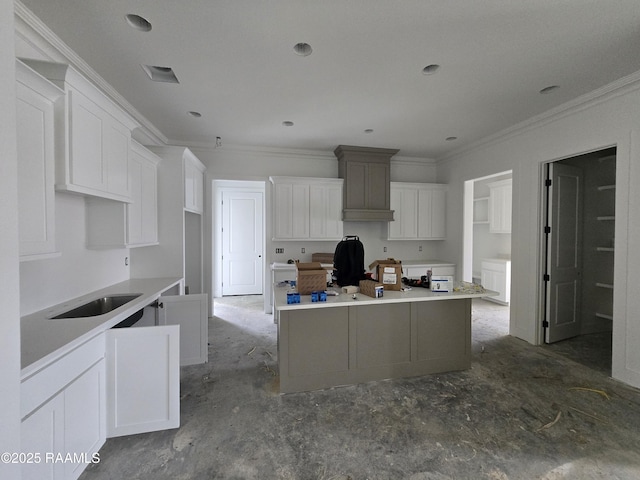 kitchen with crown molding, light countertops, white cabinetry, and a kitchen island