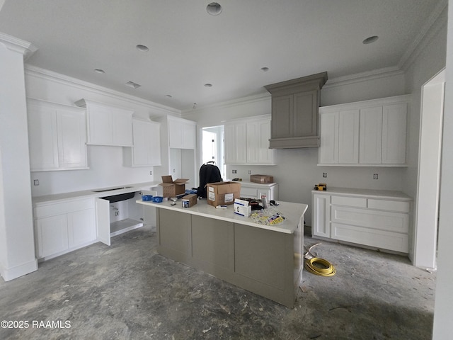 kitchen with light countertops, concrete floors, a kitchen island, and white cabinets