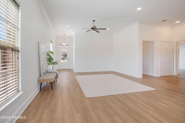 empty room with crown molding, ceiling fan, and light wood-type flooring