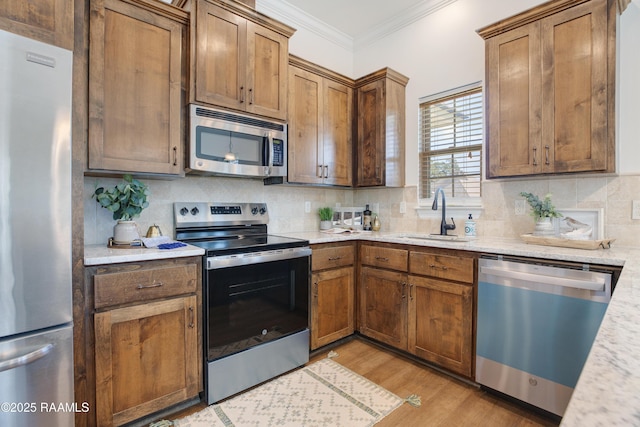 kitchen with crown molding, stainless steel appliances, sink, and tasteful backsplash