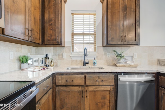 kitchen with light stone counters, sink, decorative backsplash, and dishwasher