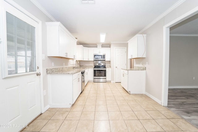 kitchen featuring sink, crown molding, light tile patterned floors, appliances with stainless steel finishes, and white cabinets