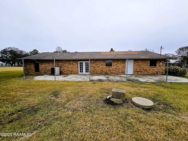 rear view of property with french doors, a yard, and a patio