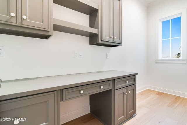 interior space featuring built in desk and light hardwood / wood-style flooring