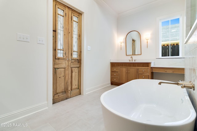 bathroom with ornamental molding, a tub to relax in, and vanity