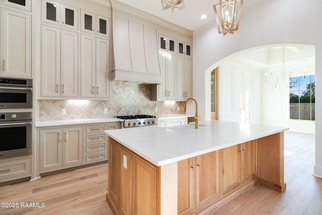 kitchen with stainless steel appliances, hanging light fixtures, a notable chandelier, and a spacious island