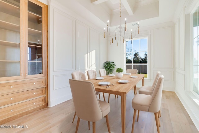 dining room featuring beamed ceiling, a notable chandelier, and light hardwood / wood-style flooring