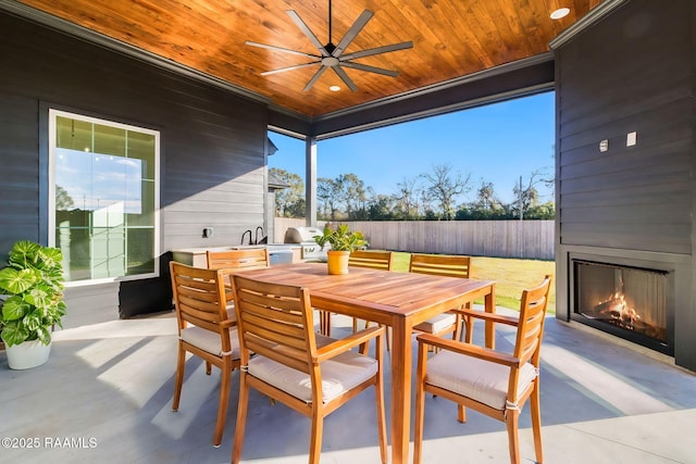 view of patio with ceiling fan and a fireplace