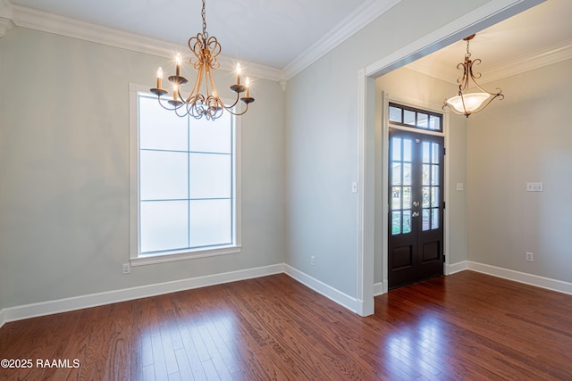 foyer featuring ornamental molding, a healthy amount of sunlight, an inviting chandelier, and dark hardwood / wood-style flooring