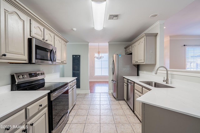 kitchen featuring sink, crown molding, light tile patterned floors, appliances with stainless steel finishes, and a notable chandelier