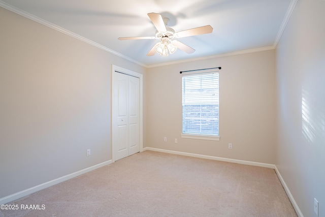 empty room with ceiling fan, ornamental molding, and light carpet