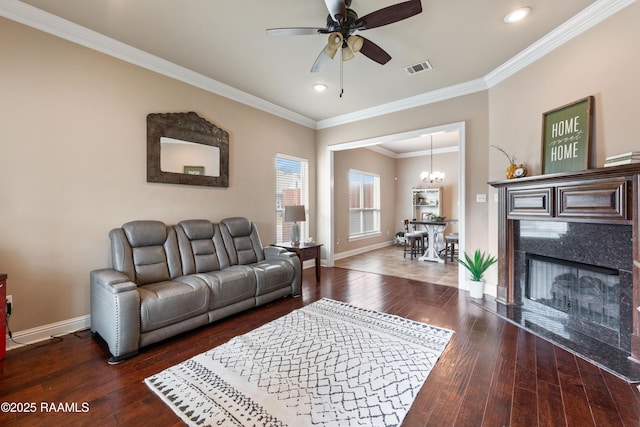 living room featuring ornamental molding, dark hardwood / wood-style floors, ceiling fan with notable chandelier, and a high end fireplace