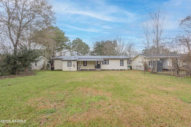 rear view of property with a lawn