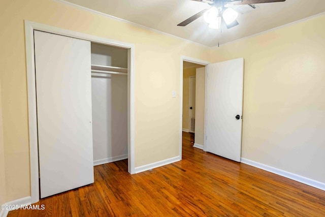 unfurnished bedroom with crown molding, ceiling fan, hardwood / wood-style floors, and a closet